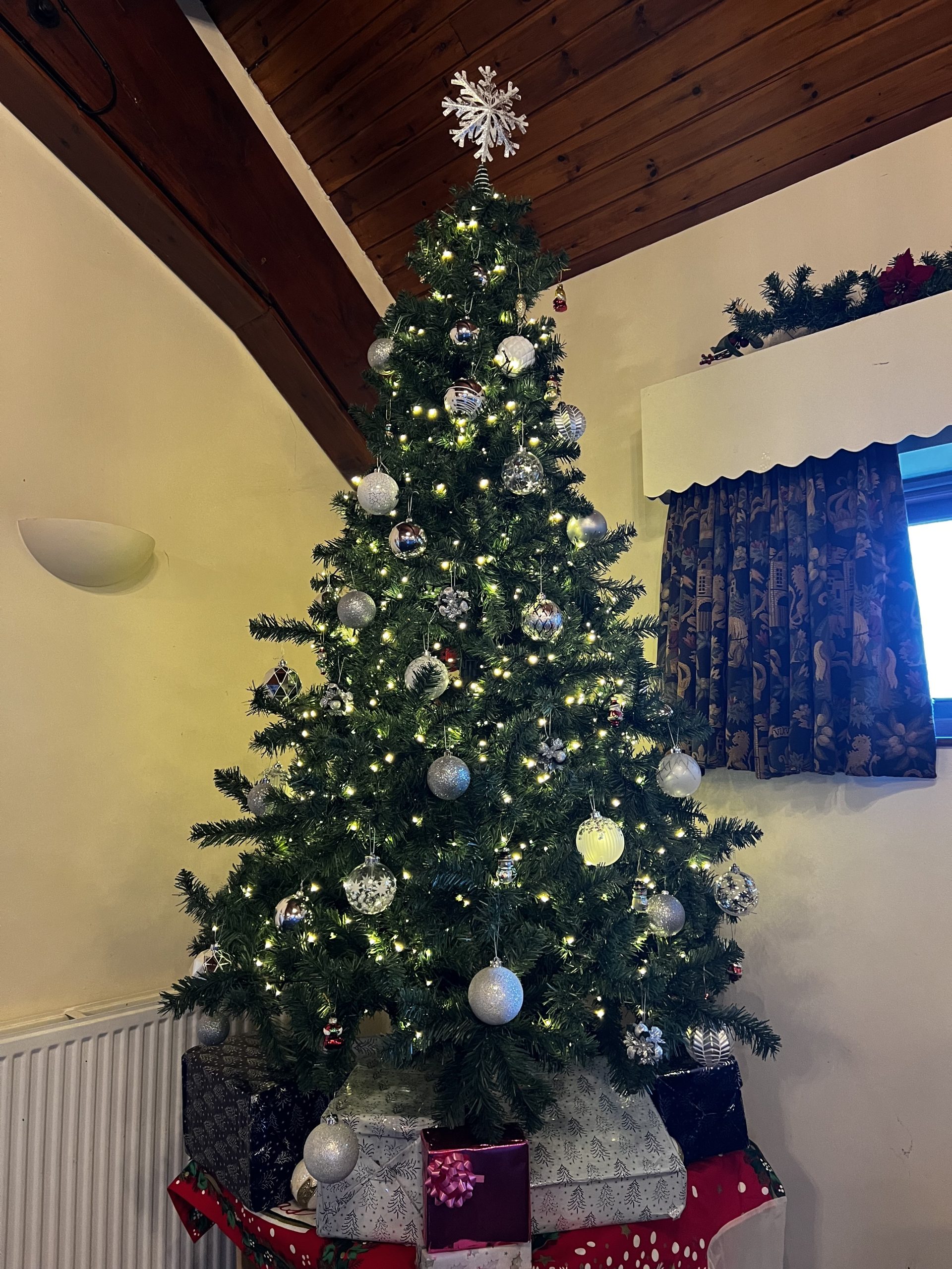 ChristmasTree A green Christmas tree with silver baubles with wrapped presents underneath