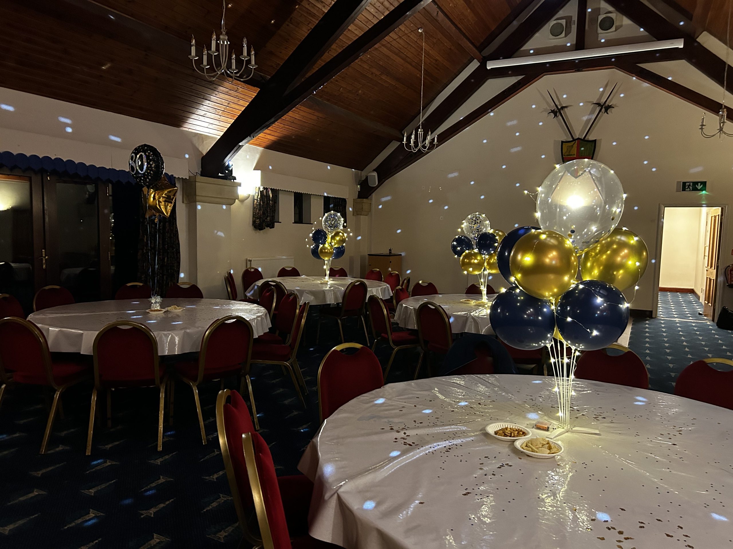 Party A dining room at The Pavilion decorated for a party with navy, gold and silver balloons
