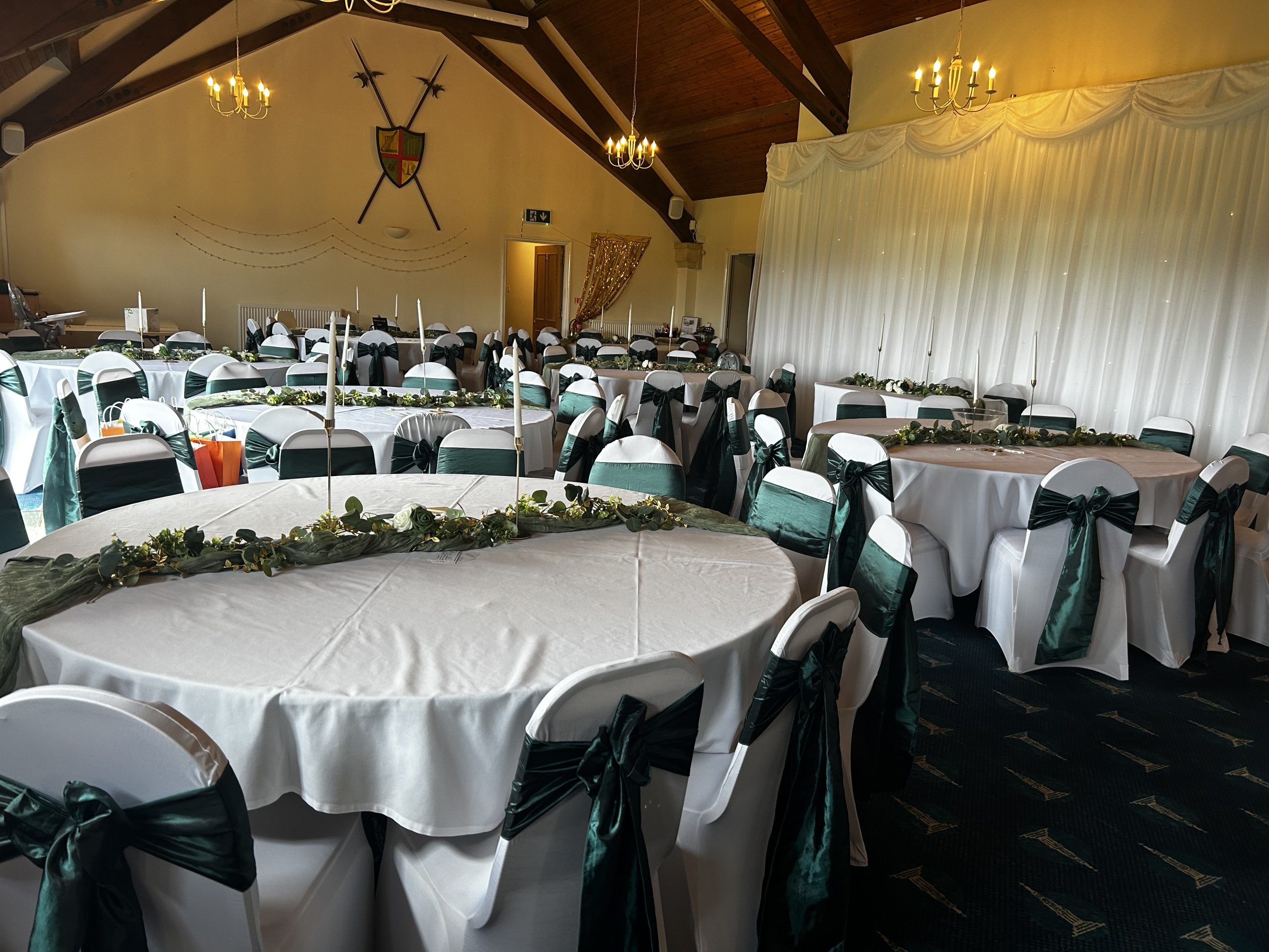 prom A dining room decorated for Prom, featuring white table cloths and green bows on chairs.